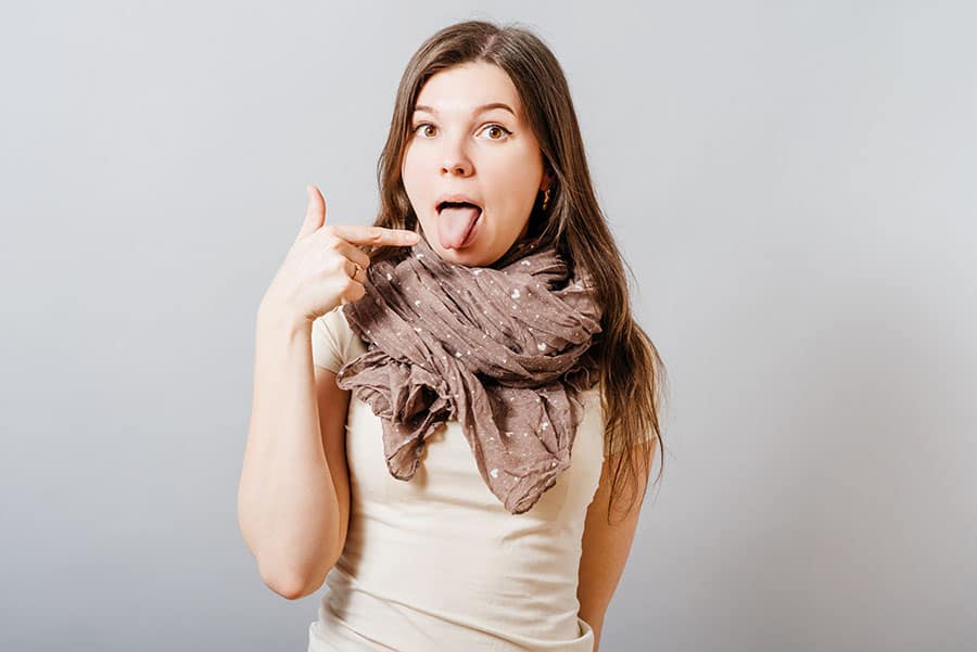 Mujer enseñando su lengua rosada