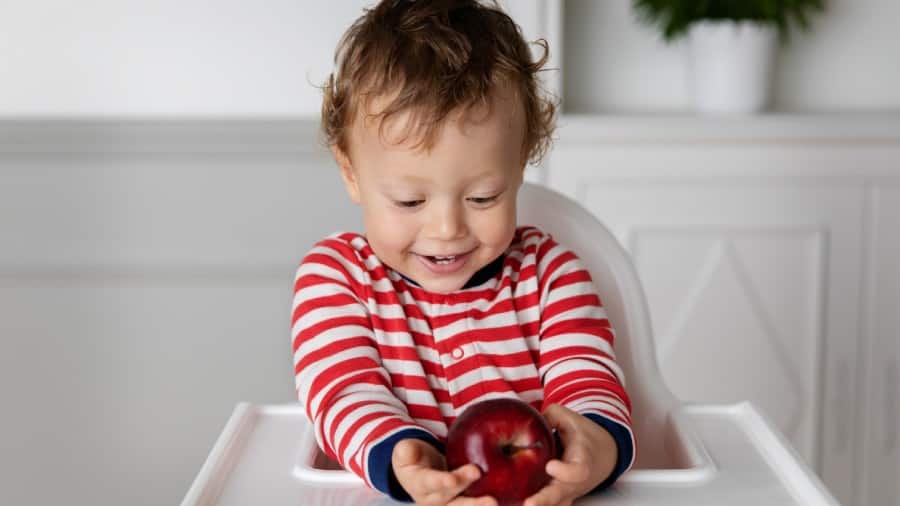 young child holding an apple