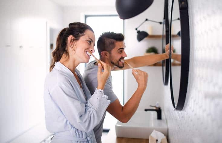 Madre e hijas felices lavándose los dientes
