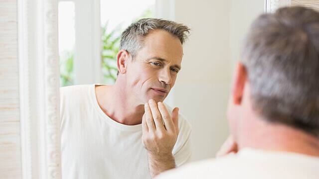 A man checking himself in the mirror