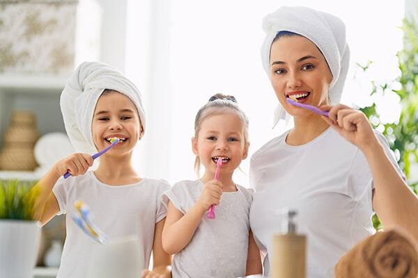 mamá e hija lavandose los dientes