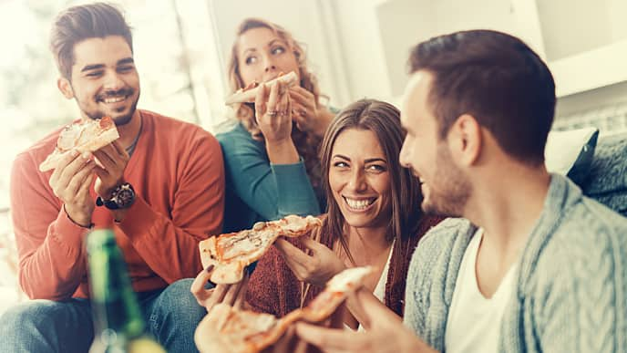 Amigos felices comiendo pizza