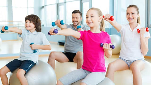 Exercising together is fun. Happy sporty family exercising in sports club together Exercising together is fun. Happy sporty family exercising in sports club together