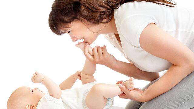 Joyful Mother Playing with her baby infant