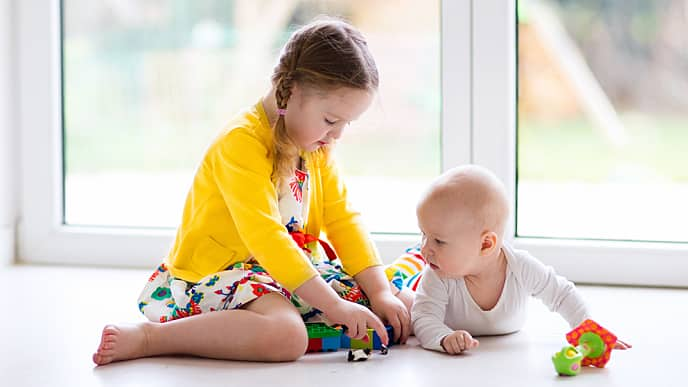 Niña jugando con su hermano bebé