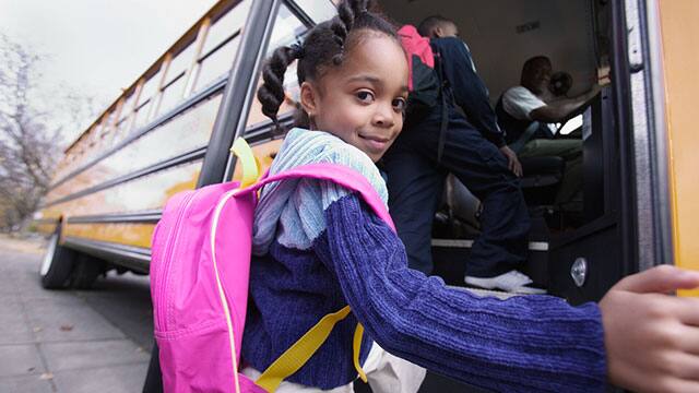 Little girl with backpack on boarding school bus Little girl with backpack on boarding school bus