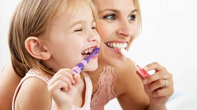 Mother and Daughter Brushing Teeth Together