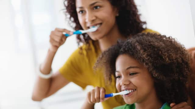 Mother and Daughter Brushing Teeth