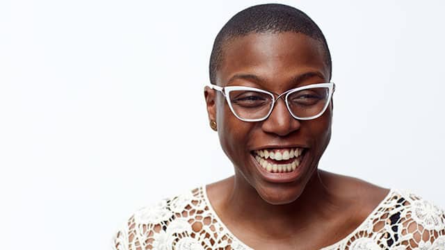woman with glasses smiling brightly
