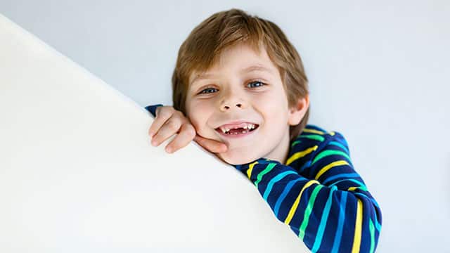 Niño dentando sonriendo con sus encías