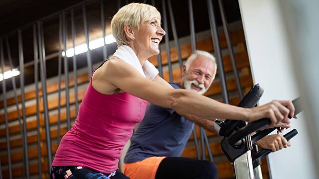 Mature fit couple exercising in gym to stay healthy