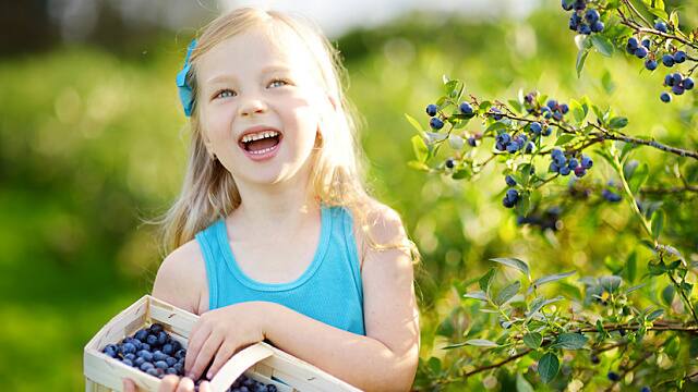 Niña en el jardín sonriendo