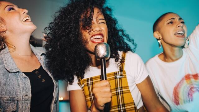 three girls singing and smiling with bright white teeth