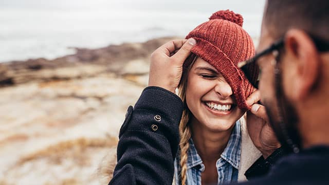 Couple having fun and laughing on a winter day at the beach