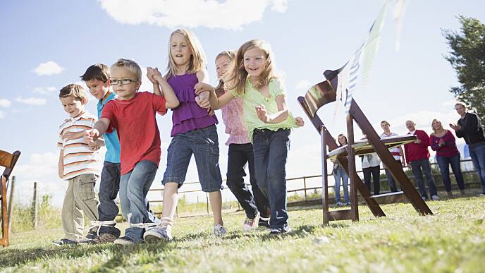 Family cheering on kids in 3 legged race