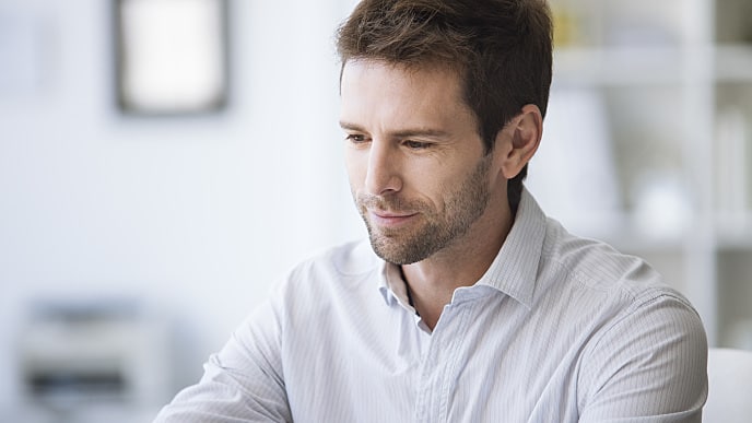 a man smiling while looking at a distance