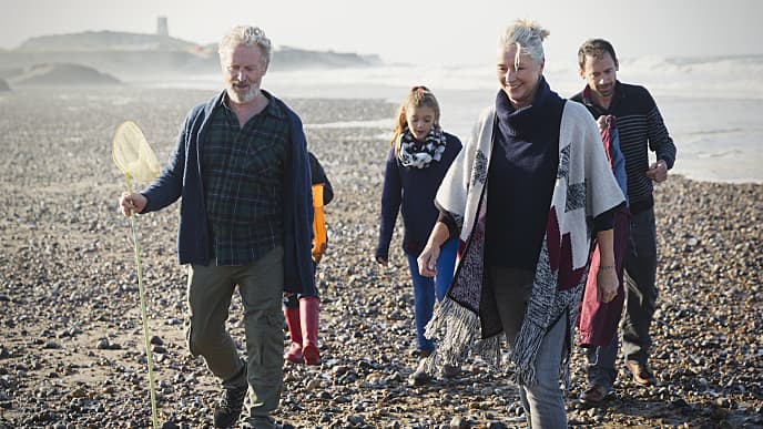Family walking on rocky beach
