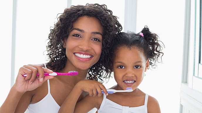 madre-e-hija-cepillandose-los-dientes-para-evitar-manchas-dentales