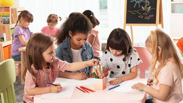 a group of children coloring in a classroom