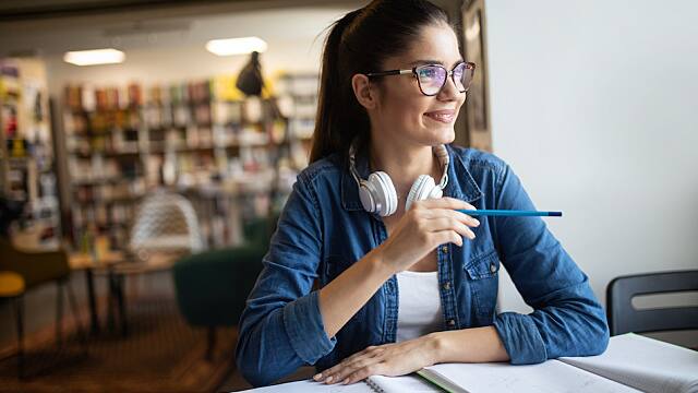 Beautiful student girl learning in a library
