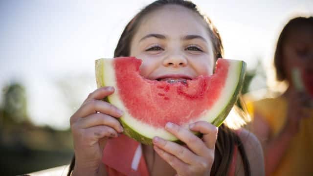 Happy girl eating watermelon