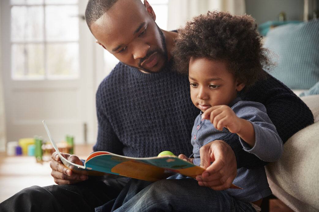 father reading book with his daughter
