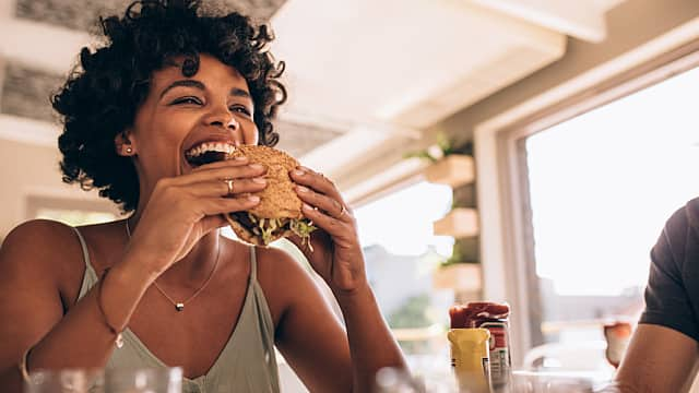 Mujer sonriendo al comer