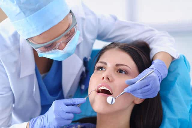 Dentista trabajando los dientes de su paciente