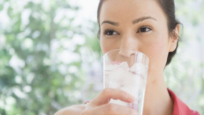 Mujer tomando agua fluorada