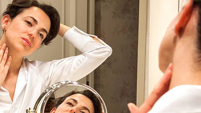 Woman looking at the mirror with her head tilted to the side