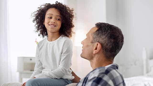 Padre e hija sonriendo mientras hablan