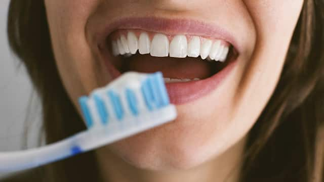 close-up of a young woman brushing her teeth 