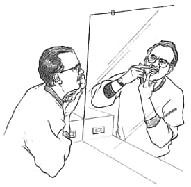 Persona revisando sus dientes en el espejo