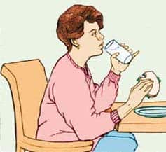 Mujer bebiendo líquidos mientras come