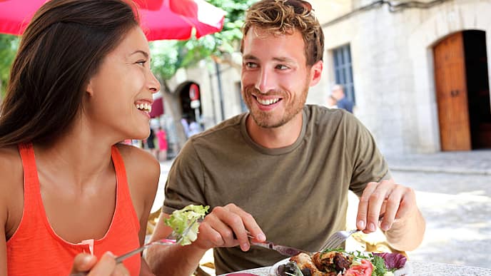 Restaurant tourists couple eating at outdoor cafe. Summer travel people eating healthy food together