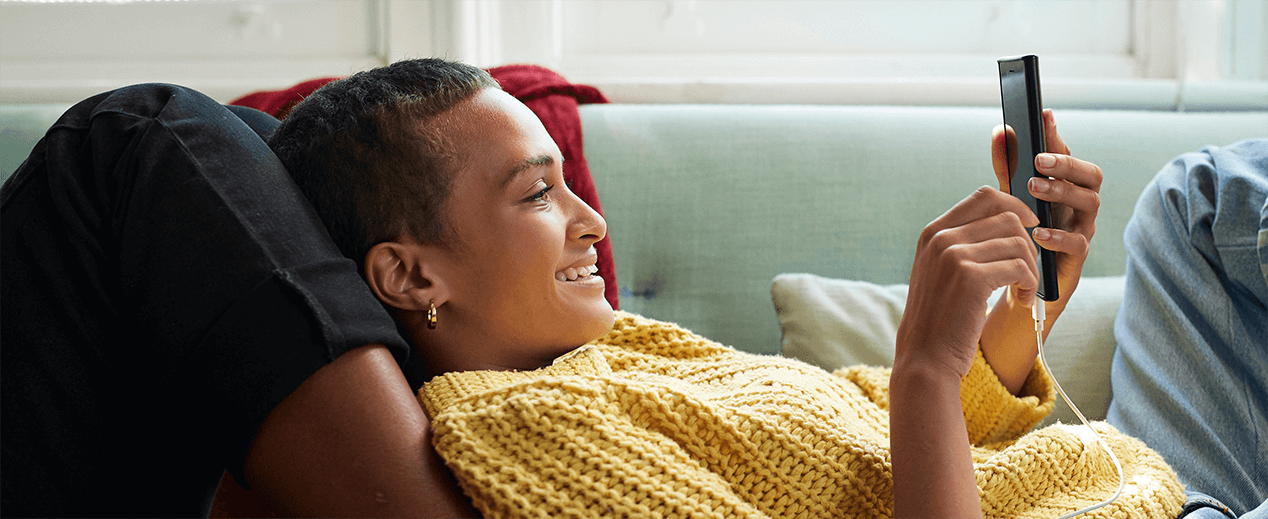 Mujer sonriendo y mirando su celular