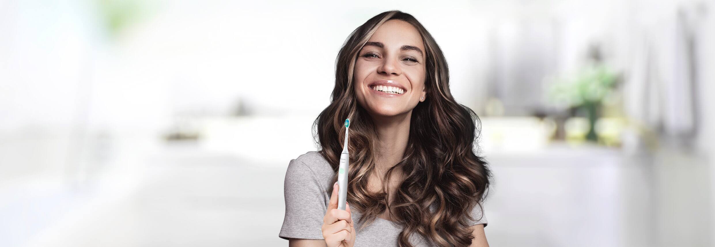 Mujer sonriendo con su cepillo sonicpro 10