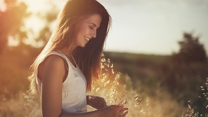 Mujer en un campo sonriendo