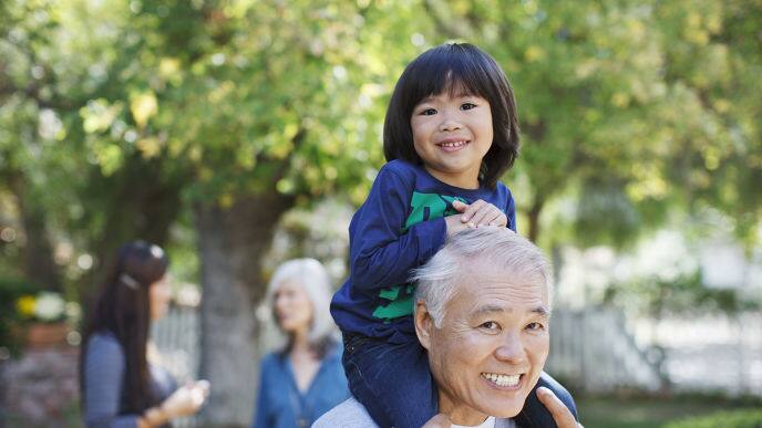 smiling lady with grey hair holding child 