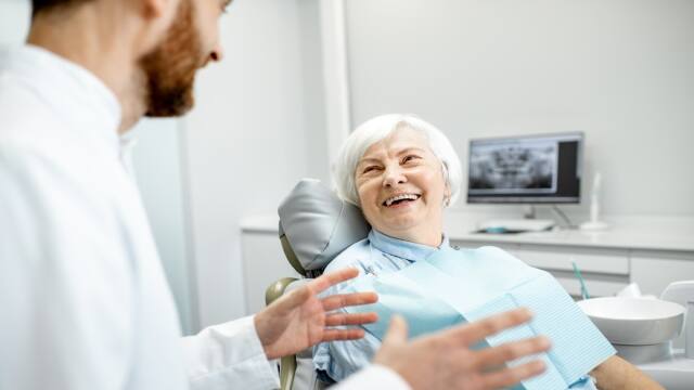 older woman with sitting during the consultation with dentist at the dental office. older woman with sitting during the consultation with dentist at the dental office.