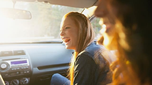 friends smiling inside car