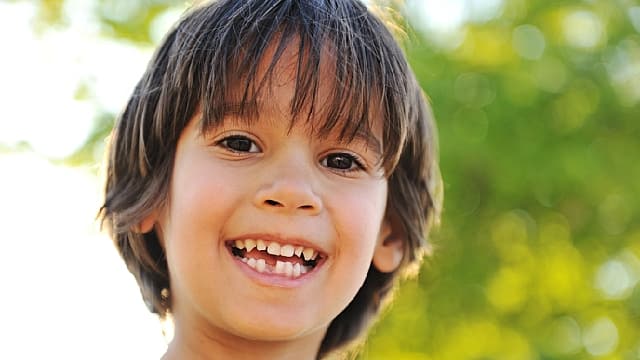 toddler showing deciduous teeth