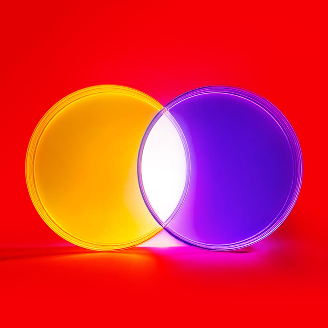 A yellow and purple circle with a white intersecting area in the middle to demonstrate purple colour-correcting yellow
