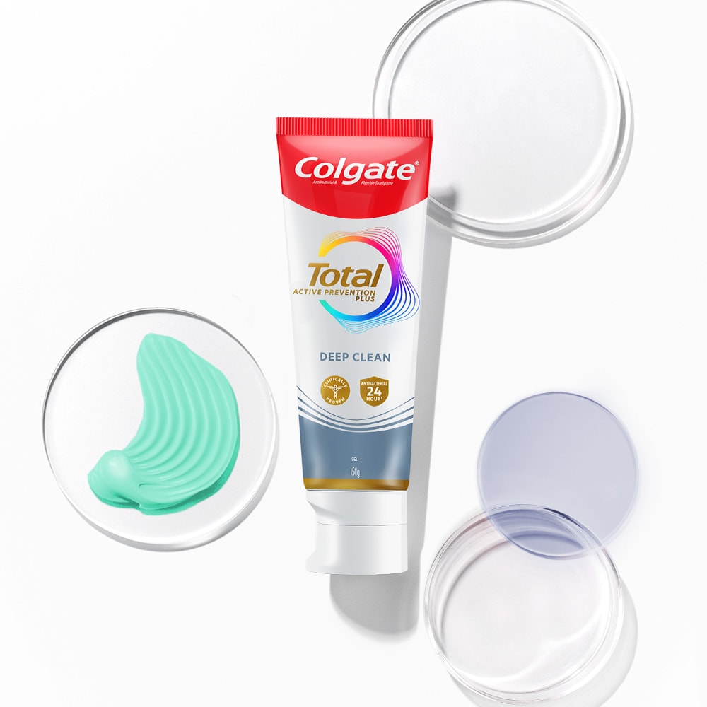 Colgate Total toothpaste tube in the foreground, with transparent and spectrum bubbles in the background