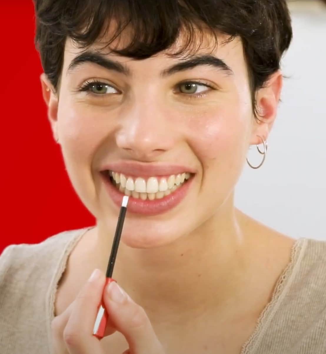 Mulher com o soro branqueador Max White Overnight Whitening Serum na mão