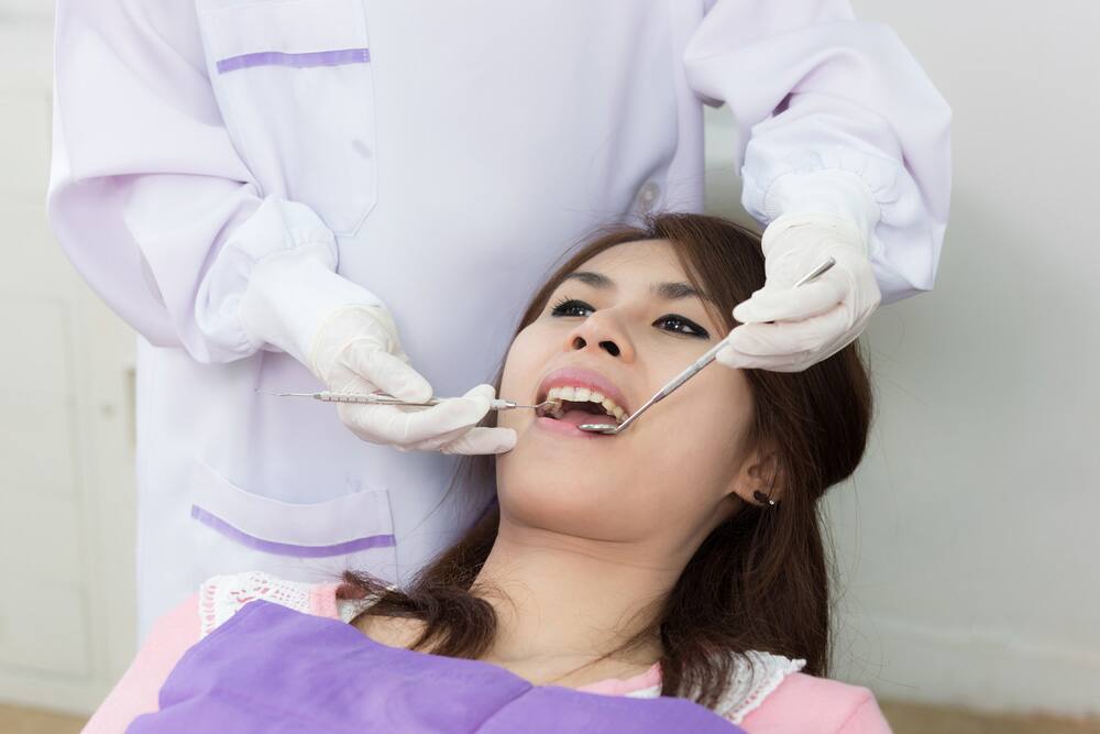 Dentist examine asian woman patient