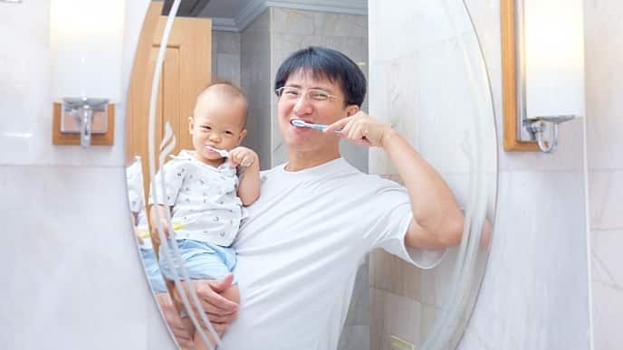Asian Father teaching kid teeth brushing