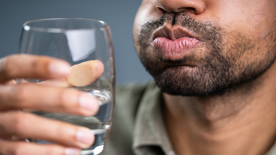 Man rinsing his teeth with water