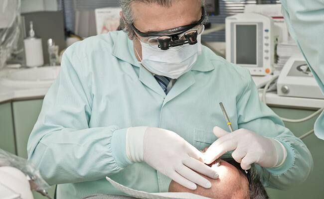Bir hastaya tedavi uygulayan dişçi
